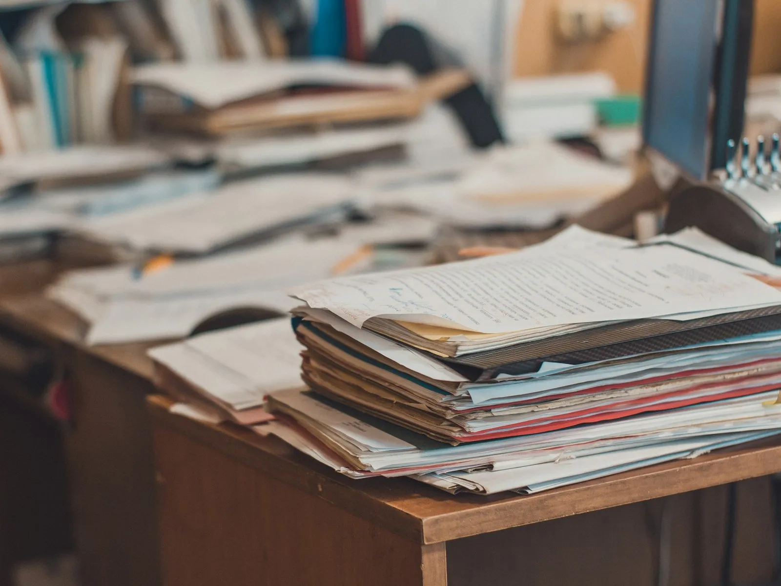 Escritorio cubierto de pilas de papeles y carpetas